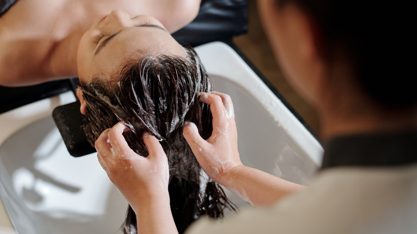 Woman receiving relaxing hair spa therapy at salon